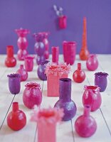 Viele zarte, verspielte Vasen aus Transparentpapier in Beerenfarben