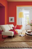Sofa beige vor orange pink Wand, Lampe gelb, Kissen, Stehlampe gelb