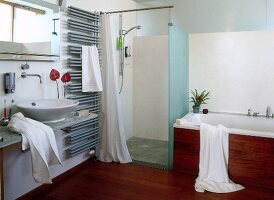 View of bathroom with tropical wooden floor, bathtub, shower and sink