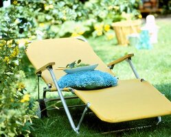 Close-up of yellow garden chair with aluminium frame in garden