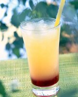 Glass of tequila sunrise with grenadine syrup, lemon juice and orange juice