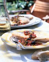 Pesce spada alla siciliana with swordfish, tomatoes and capers on plate