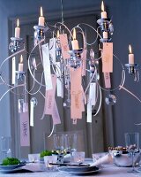 am Kerzenkronleuchter hängen neben Glasprismen die Namen aller Gäste