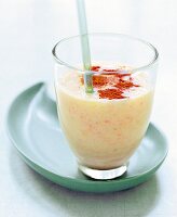 Glas Grapefruit-Bananen-Shake mit Strohhalm und Zimtpulver