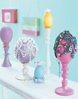 Ostereier, auf Kerzenständern, dekoriert mit Glasperlenketten