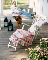 Blanket and pillow on deck chair from white wood