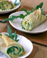 Mini wraps with cheese, carrots and rocket filling on plates