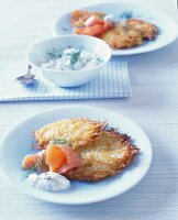 Potato pancakes and salmon with skimmed curd sauce on plate