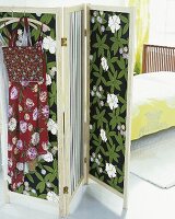 Paravent mit Blüten - und Streifen stoff bespannt, Bett im Hintergrund