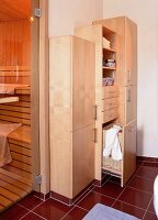 Unterschiedlich hohe Holzschränke neben einer Sauna