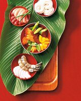 Bowl of vegetables, fish and shrimp for served on turmeric leaf for preparing fondue dish