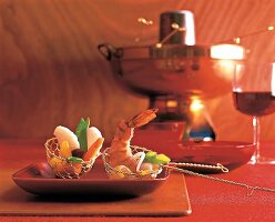 Shrimp, fish, meat and vegetables cook in basket for making soup