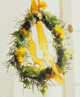 Close-up of floral wreath with yellow ribbons