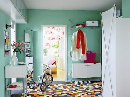 Hallway with colourful tiles, white wardrobe and telephone table