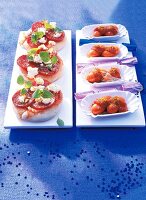 Mini pepperoni pizza and sausage in serving dish on blue background