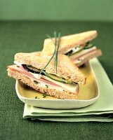 Whole grain bread sandwich with turkey and vegetable on serving dish