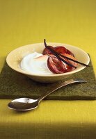 Quark cream with halved plums in bowl