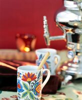 Close-up of colourful tea cup with samovar at background