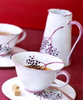 Teetasse und Kanne mit Holundermotiv 