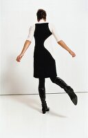 Frau in schwarzem Etui-Kleid 60er-Jahre-Stil
