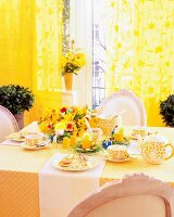 Dining table laid for Easter with yellow flowers, Easter decorations