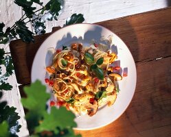 Spaghetti with mushrooms and turkey breast on plate, overhead view