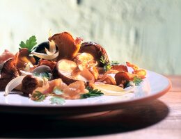 Close-up of fried mushrooms with bacon on plate