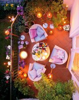 Balcony with lit candles, patio, cushions and flowers, overhead view