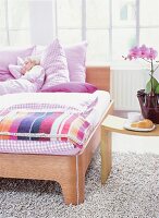 Peaceful woman sleeping on wooden bed with pink bedding, pillows and bedspread
