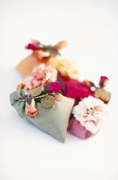 Colourful incense bags with dried rose petals on white background
