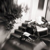 Dirty clothes and office equipment scattered on staircase, blurred motion, black and white
