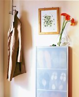 Flur in Beige: Wand mit Schuhschrank Blumenvase, Bild u. hängendem Mantel
