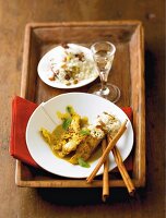 Spicy rice with coconut chicken on a white plate