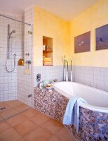 Bath tub with mosaic tiles and shower cubicle in bathroom