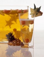 Exotic punch with garnishing of pineapple and star fruit in glass