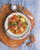 Lamb stew in bowl on tree stump