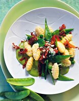 Gnocchi with peas on plate, overhead view