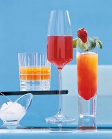 3 Cocktails vor blauem Hintergrund: Sherry Sour, Peach Cava u.a