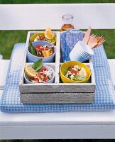 Several bowls of ebly salad in wooden box