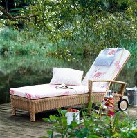 Wicker sun lounger with wheels in garden