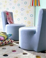 Blue cocktail chair on woolen carpet against wallpaper with colourful circles