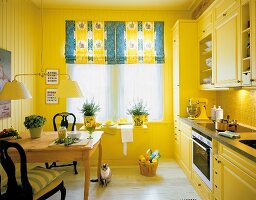View of kitchen with blinds, yellow walls and cabinets