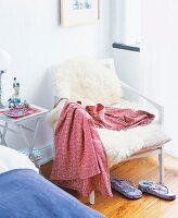 White garden wooden chair with sheepskin in bedroom