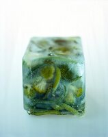 Green mixed vegetables frozen in cubes on background