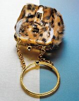 Close-up of furry evening handbag with golden handle