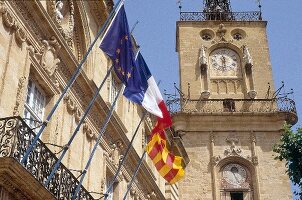 City hall with tower and various flags at Aix-en-Provence, France