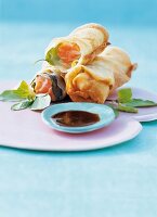 Salmon spring rolls with wasabi sauce on plate