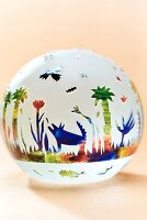 Close-up of ball paperweight with colourful jungle world