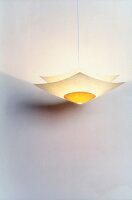 Illuminated yellow paper lamp hanging on white background