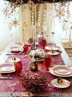 Banquet table set festively with pearl necklaces hanging above